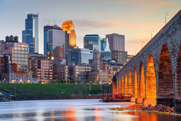 Minneapolis, Minnesota, ABD. Mississippi Nehri 'ndeki Stone Arch Köprüsü ile mavi saatte gökyüzü..