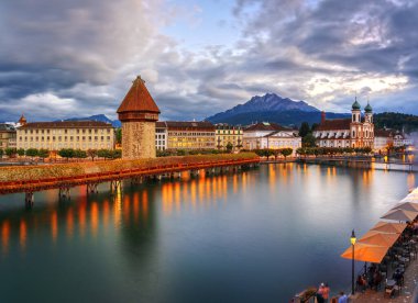 Lucerne, İsviçre 'de Chapel Köprüsü ve Reuss Nehri üzerindeki su kulesi alacakaranlıkta..