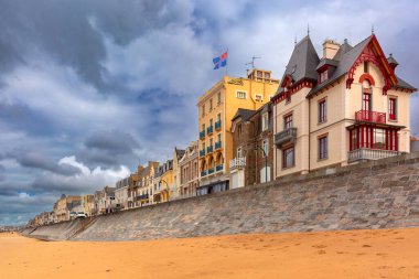 High stone embankment and beach at low tide, in beautiful Saint-Malo, Brittany, France clipart