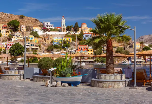 stock image Hillside view of the colorful buildings and busy harbor on Symi Island, Greece.