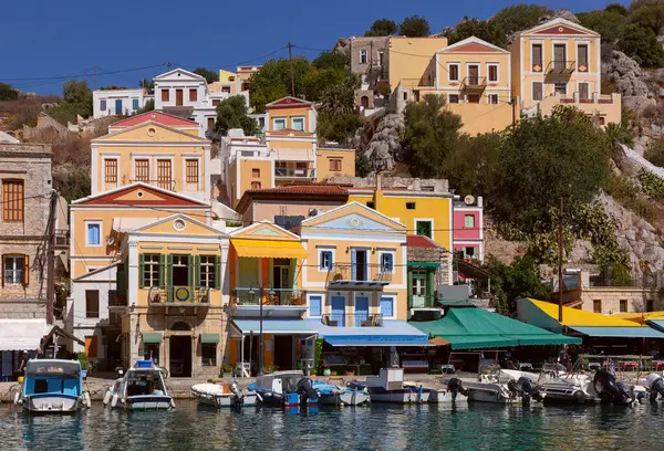 stock image Hillside view of the colorful buildings and busy harbor on Symi Island, Greece.