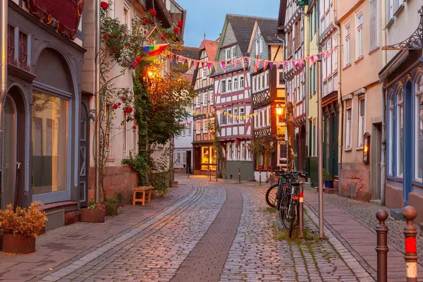 stock image Colorful old town street in Marburg, Germany, half-timbered houses and festive decorations at dusk