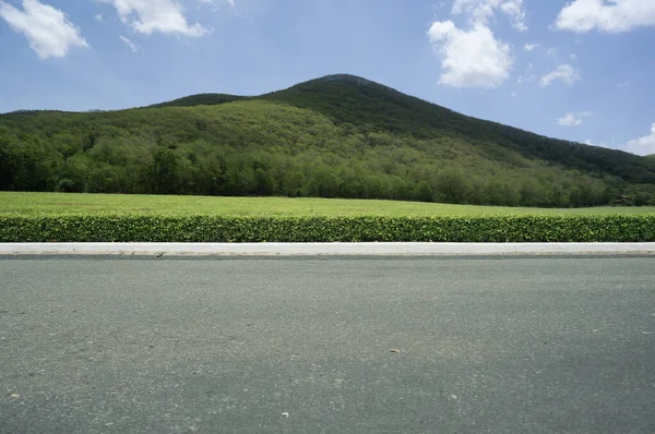 空のアスファルト道路と曇りの山の側面図 — ストック写真