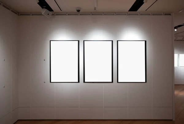 在一个房间里 靠着一面白色的墙 空出三个框架 — 图库照片