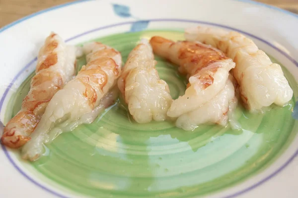 stock image raw shrimps peeled and arranged in a row on a plate 