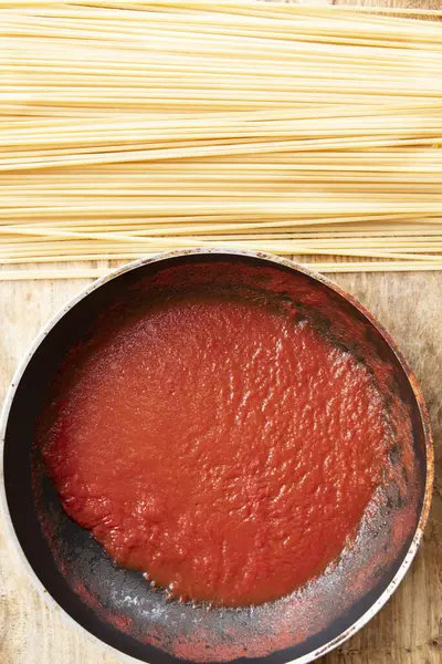 Rauwe Spaghetti Bij Een Pan Met Tomatensaus — Stockfoto