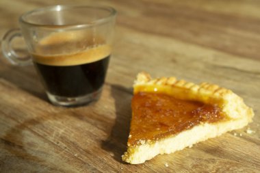 Bir fincan espresso ve yanında bir dilim turta.