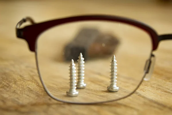 stock image precision handwork concept with screws seen through glasses