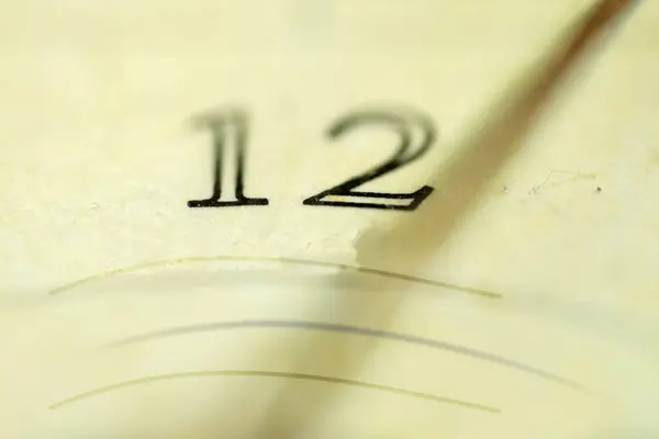 stock image concept of time with the face of an old clock and the drop shadow of a clock hand