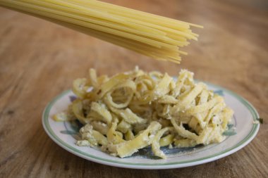 Çiğ spagetti ve ricotta ile bir tabak tagliatelle.