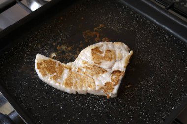 Izgara tavada ızgara kılıçbalığı filetosu.