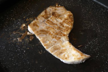 Izgara tavada ızgara kılıçbalığı filetosu.