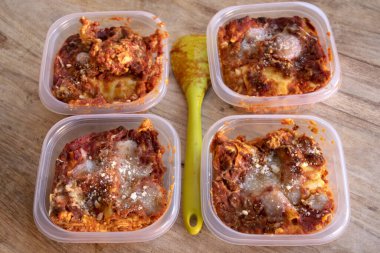 Ev yapımı lazanyanın bireysel kısmı tek kullanımlık beslenme çantasına konur.