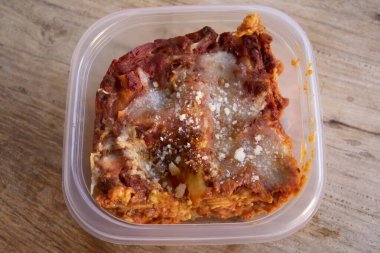 Ev yapımı lazanyanın bireysel kısmı tek kullanımlık beslenme çantasına konur.
