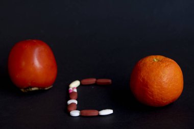 İki meyveli C vitamini konsepti ve haplarla yazılmış C vitamini.