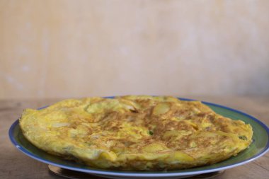 Arkaplanda brokoli tabağı olan patates omleti.