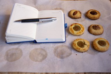 Ev yapımı çay bisküvileri, Neal 'la birlikte bir yemek tepsisine dizilmiş bir defter.