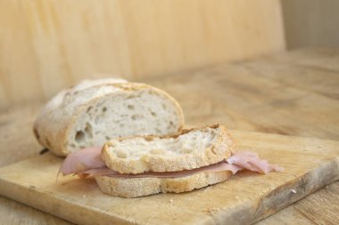 Ekmek ve mortadella dilimlerinden yapılmış bir sandviç.