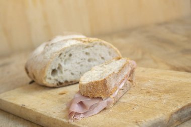 Ekmek ve mortadella dilimlerinden yapılmış bir sandviç.