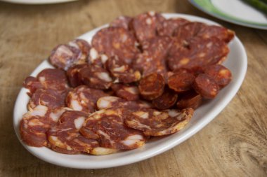 Calabrese sosisi ve soppressata da dahil olmak üzere çeşitli geleneksel İtalyan etleri. Dilimlenmiş salamların canlı kırmızı renkleri ve mermer yağları zengin lezzetlerini ve zanaatkar hazırlıklarını ön plana çıkarıyor. Otantik Akdeniz c 'sini göstermek için mükemmel
