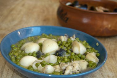 Mavi bir tabakta bezelyeli mürekkep balığı. 