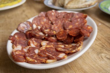  Calabrese sosisi ve soppressata da dahil olmak üzere çeşitli geleneksel İtalyan etleri. Dilimlenmiş salamların canlı kırmızı renkleri ve mermer yağları zengin lezzetlerini ve zanaatkar hazırlıklarını ön plana çıkarıyor. Orijinal Akdeniz 'i resmetmek için mükemmel 