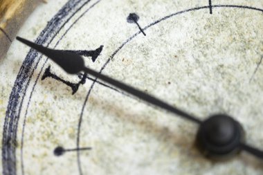 Bir duvar saatinin üzerindeki saat kolunun yakın çekimi, zamanın geçişini ve kısacık anları sembolize eder.