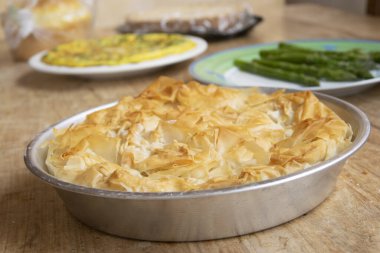 Taze pişmiş, alüminyum tavada altın filo pastası, gevrek ve gevrek. Yumuşak odaklı arkaplan: omlet ve beyaz kuşkonmaz. Kırsal yemek ayarları