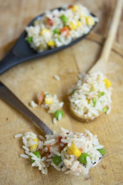 Bezelye, mısır ve domatesli canlı bir sebze salatası. Köy ahşap yüzeyinde taze malzemelerle çevrili.