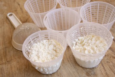 Plastik kalıplı ev yapımı ricotta peyniri süzmeye ve şekillendirmeye hazır. Mutfak ve yiyecekle ilgili içerik için mükemmel