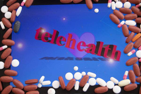 планшет с текстом "telehealth" и сердцем, обрамленным различными таблетками, символизирующими удаленное здравоохранение и цифровую медицину