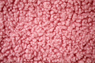 Yumuşak, pembe bir buket kumaşın yakın çekim görüntüsü. Pürüzsüz, kıvrımlı dokusunu gözler önüne seriyor. Moda, döşeme ya da iç tasarım uygulamaları için ideal bir malzeme gibi görünüyor..