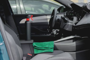 Arabanın içinde temizlik malzemeleri ve mikrofiber kumaş var.