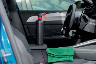 Arabanın içinde temizlik malzemeleri ve mikrofiber kumaş var.