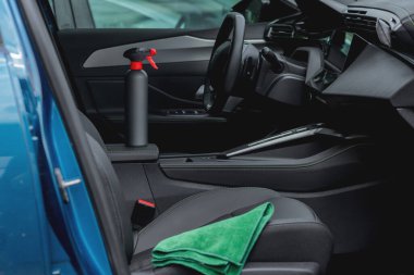 Arabanın içinde temizlik malzemeleri ve mikrofiber kumaş var.