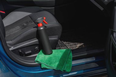 Arabanın içinde temizlik malzemeleri ve mikrofiber kumaş var.