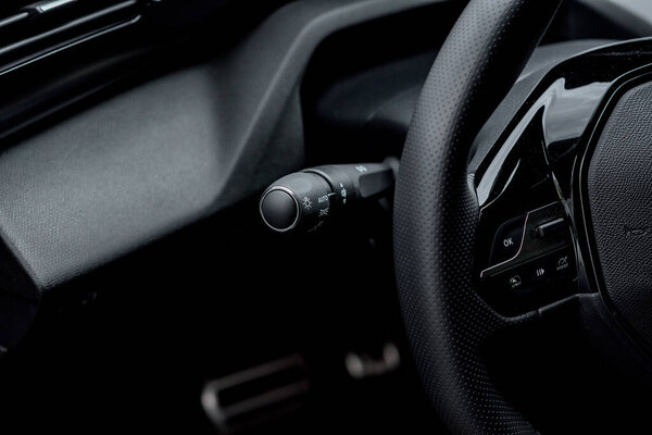 Close-up of a modern car's steering wheel and controls, highlighting the interior detail.