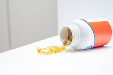 Beyaz arka planda bir kavanoz Omega 3 diyet takviyesi.