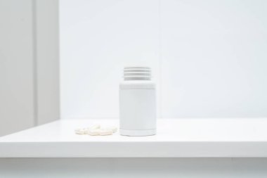 Beyaz arka planda bir kavanoz biyotin diyet takviyesi.