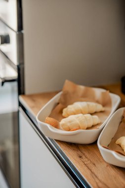 Beyaz tavada ev yapımı kruvasan pişiriyorum.