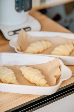 Beyaz tavada ev yapımı kruvasan pişiriyorum.