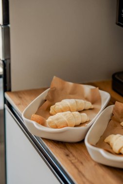 Beyaz tavada ev yapımı kruvasan pişiriyorum.