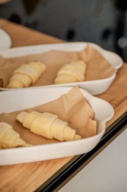 Beyaz tavada ev yapımı kruvasan pişiriyorum.