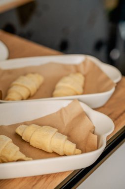 Beyaz tavada ev yapımı kruvasan pişiriyorum.