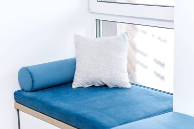 Penceresinde yastıklar olan bir oturma odası.