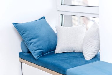 Penceresinde yastıklar olan bir oturma odası.