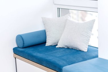 Penceresinde yastıklar olan bir oturma odası.