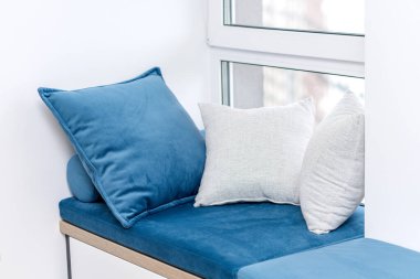 Penceresinde yastıklar olan bir oturma odası.