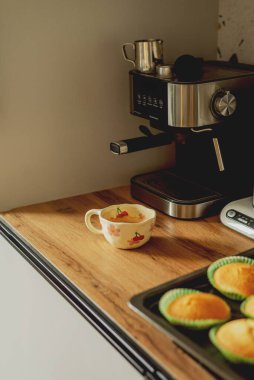 Boynuzlu kahve makinesinin yanında bir fincan kahve.