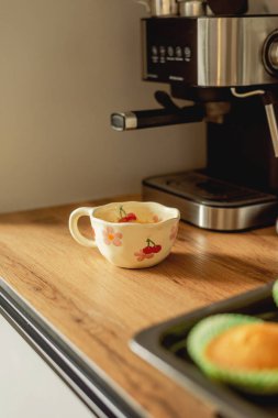 Boynuzlu kahve makinesinin yanında bir fincan kahve.